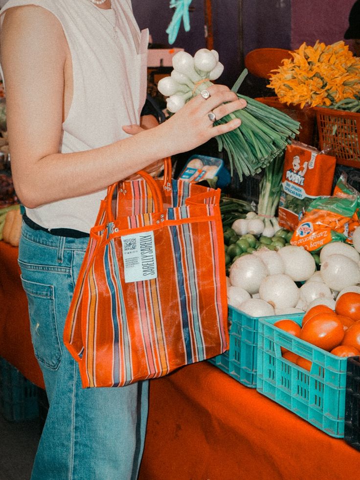 Clienta con bolsa de mandado comprando verdura