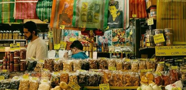 Puesto de mercado con productos a granel y letreros de precio escritos a mano