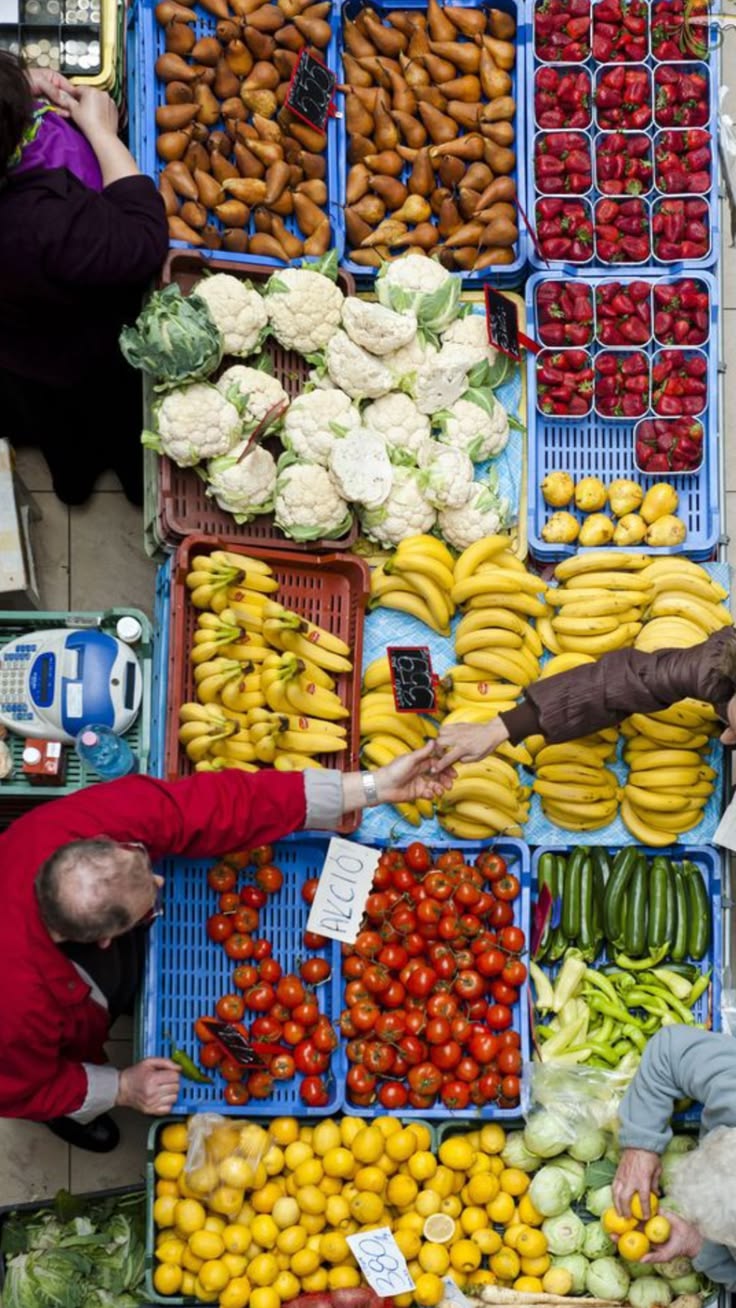 Puesto de frutas y verduras visto desde arriba, con una caja registradora